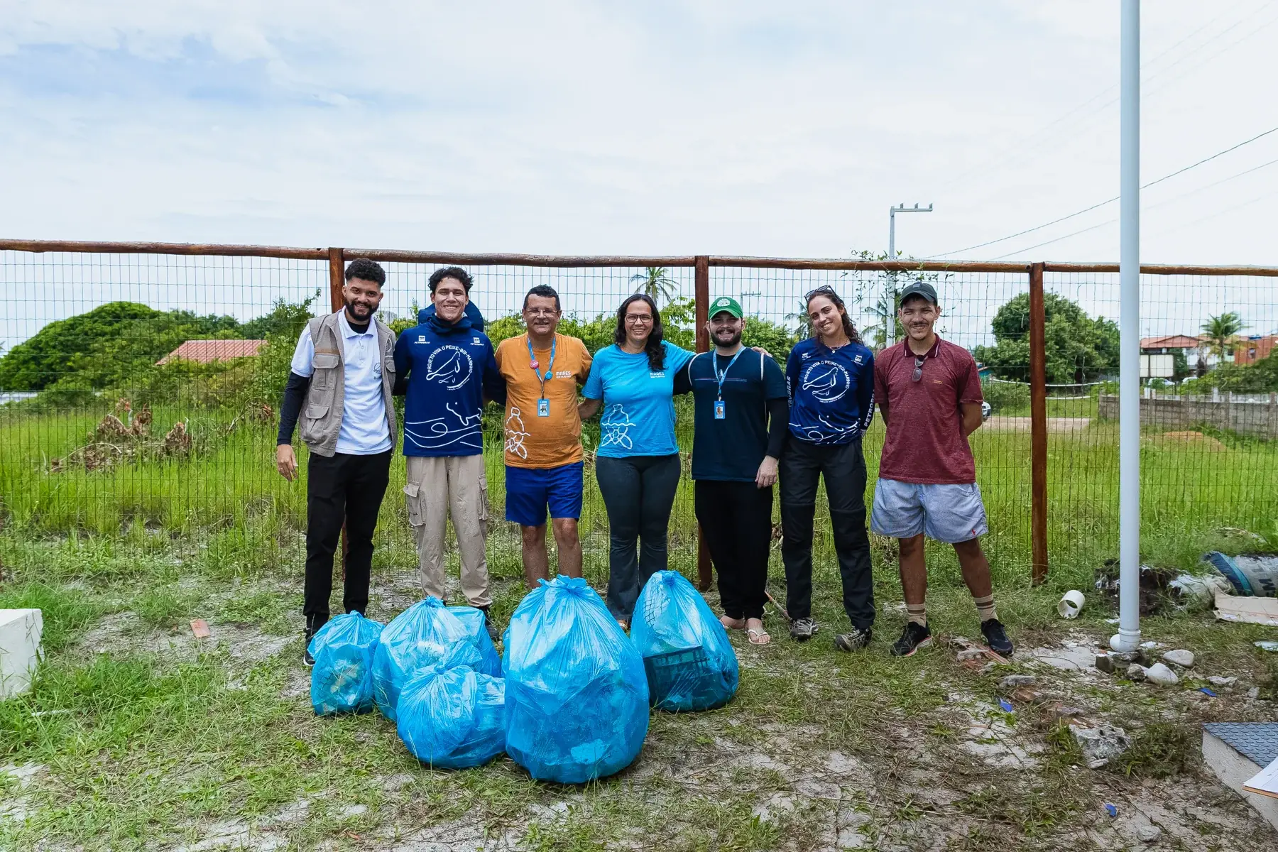 Equipe e sacos de resíduos coletados em ação ambiental